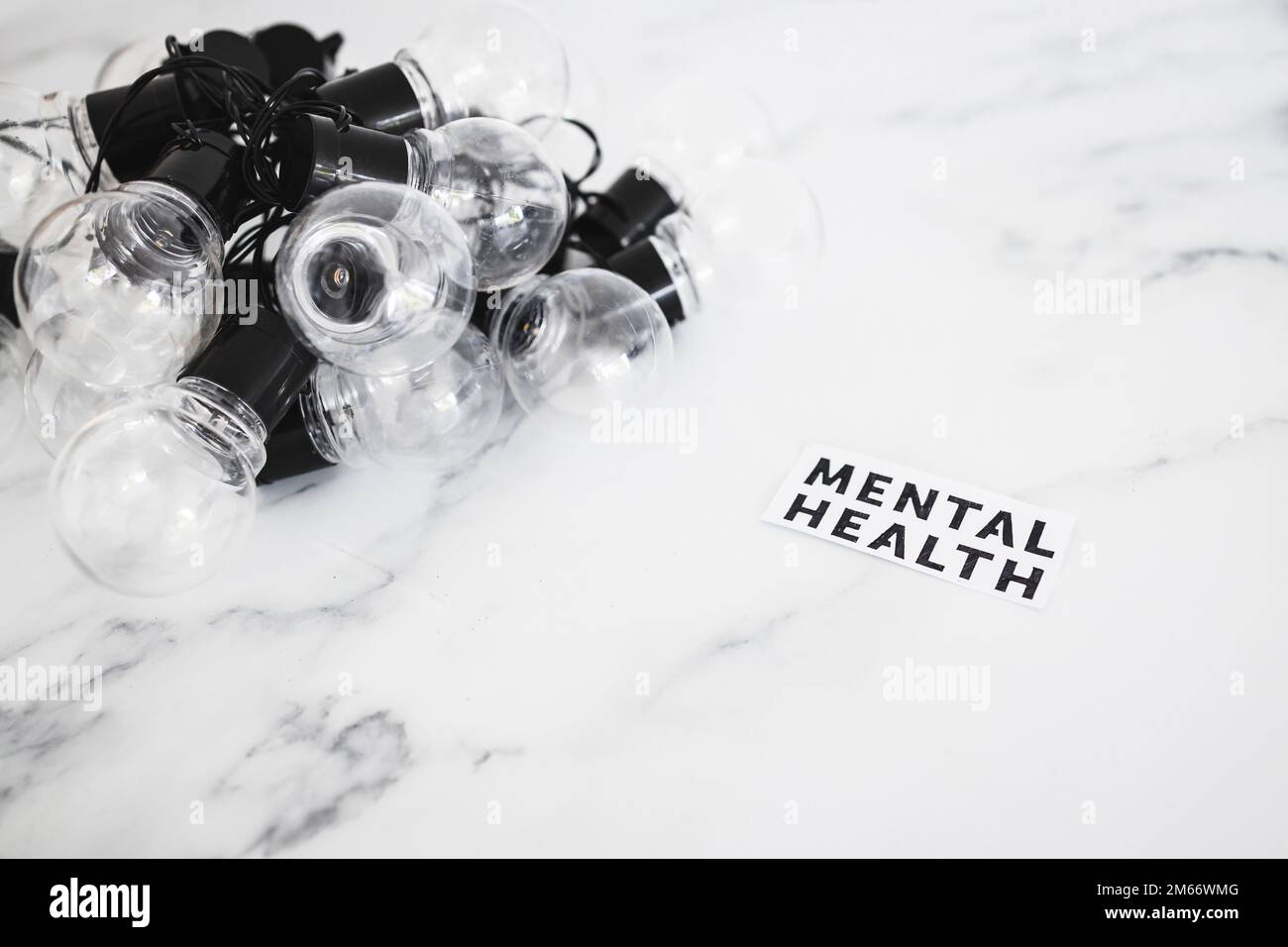 mental health text next to groupd of tangled up light bulbs, psychology concept Stock Photo