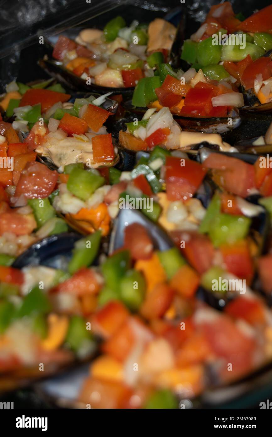 cooked mussels stuffed with red and green peppers and vinegar sauce