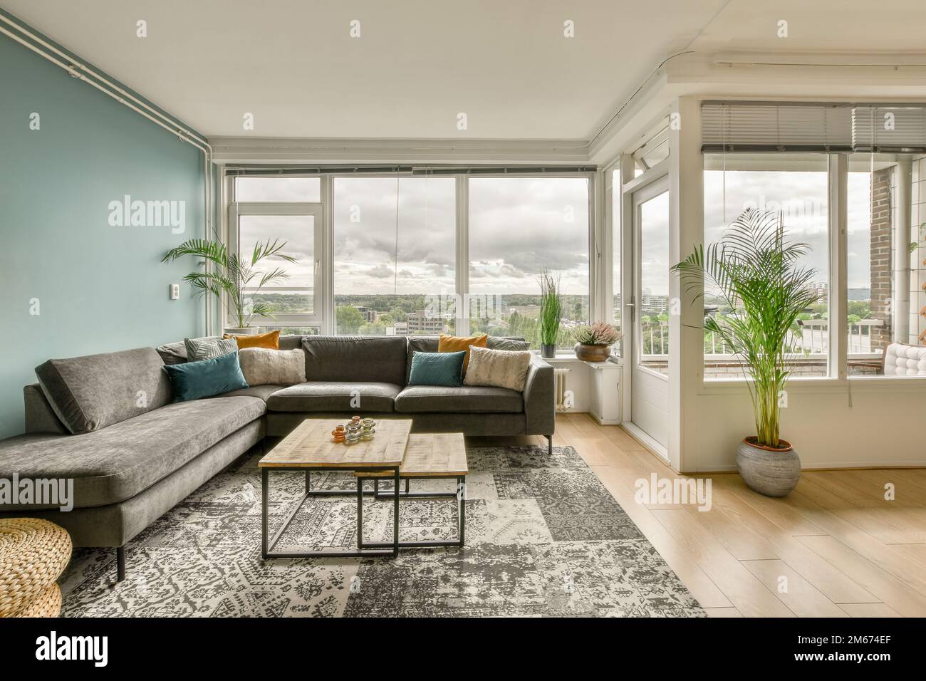 a living room with couch, coffee table and large window looking out