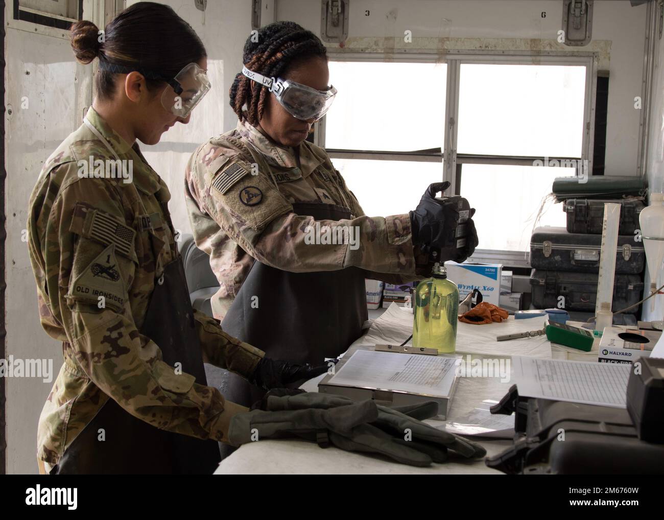 Sgt. Shandora R. Brooks, right, takes a fuel sample for testing while Spc. Mariah N. Lopez observes during a fueling mission on Erbil Air Base, Iraq, April 9, 2022. Brooks, a petroleum laboratory specialist, is assigned to 264th Combat Sustainment Support Battalion, and has been deployed with the unit since September of 2021. Stock Photo