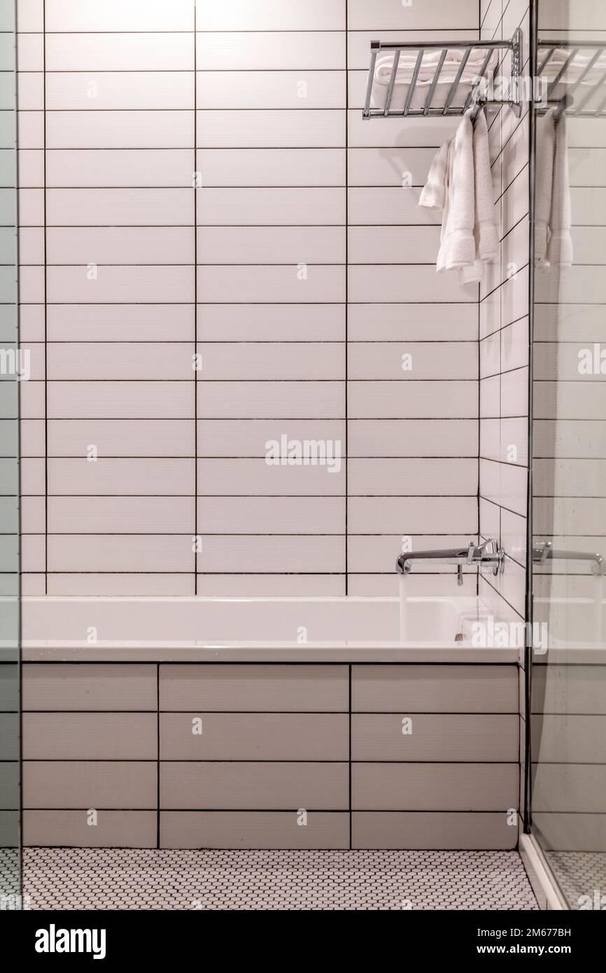 Detail of a bathroom with white tiles covered walls in a hotel Stock Photo