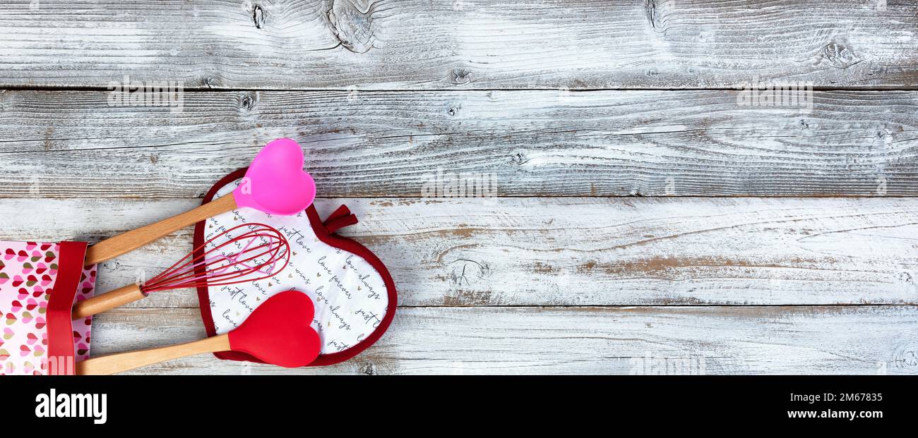 Pot holder heart pattern with kitchen utensils on white wood background for a happy Valentines day concept Stock Photo