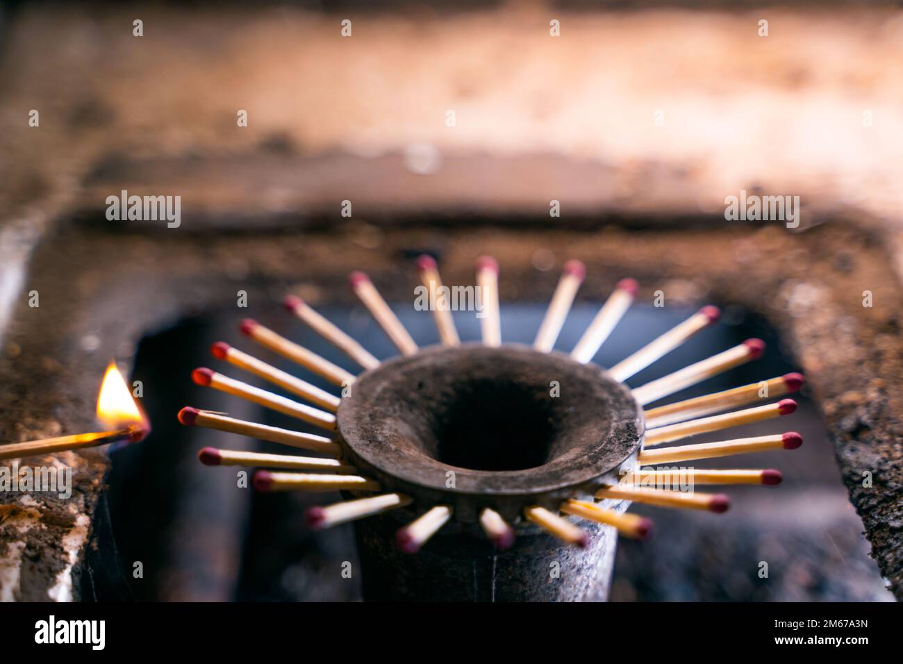Limited resource for heating and cooking. Wooden matches instead of fire in the burner of a gas stove close-up. Low standard of living, survival in po Stock Photo