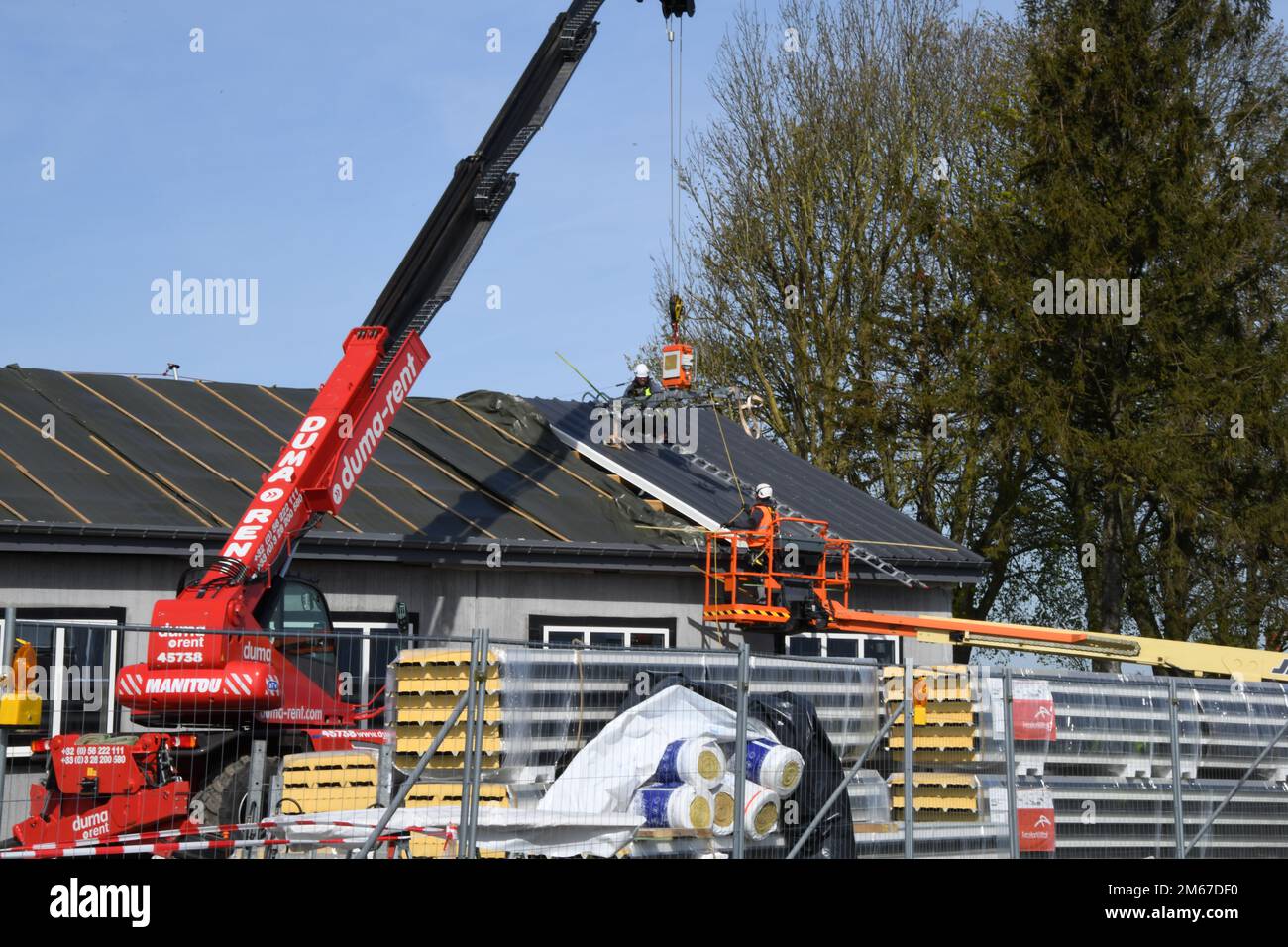 Contractors with Belgian construction firm “Toitures Bernard” release a sandwich panel during renovation of Bldg 20029 on Chièvres Air Base, Belgium, April 11, 2022. Stock Photo