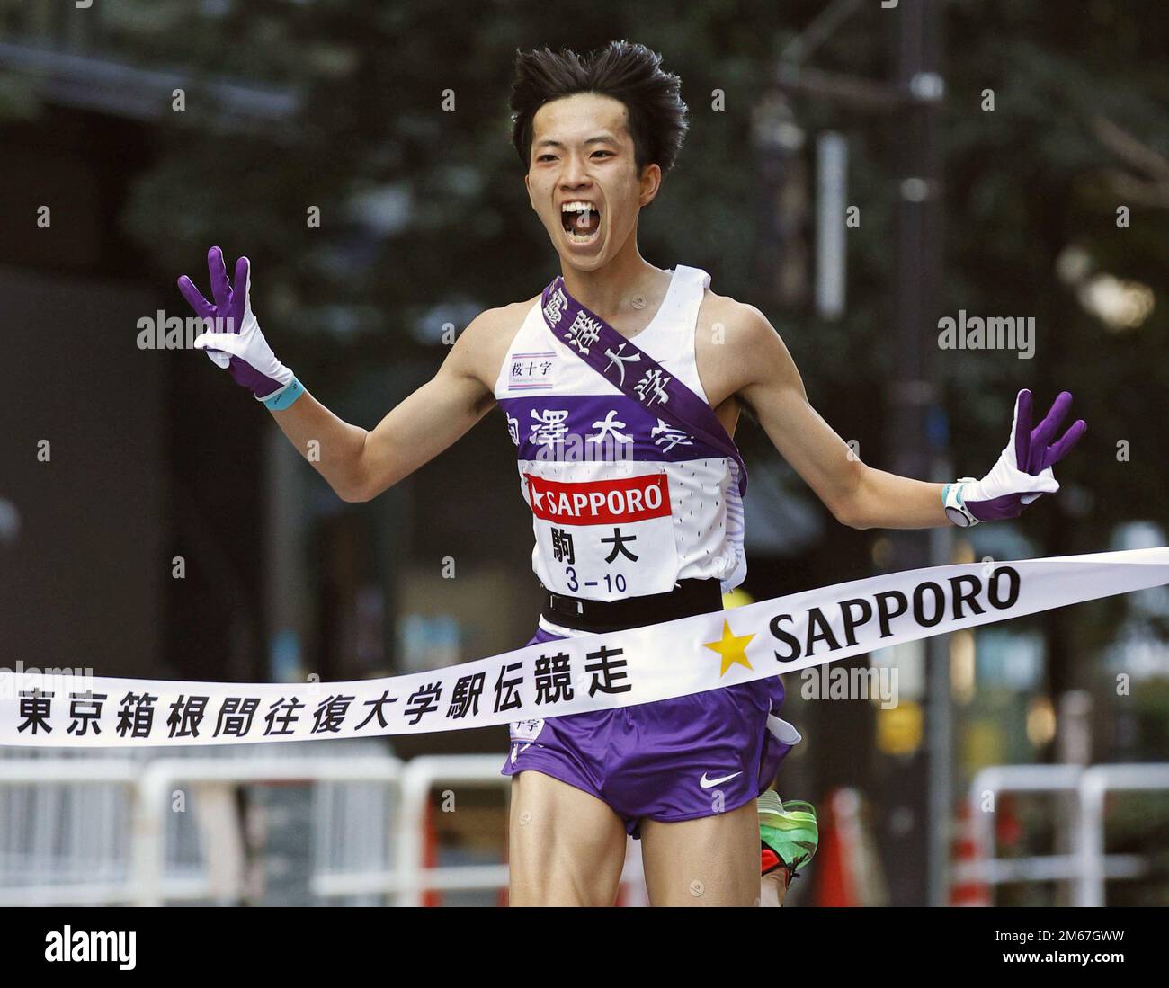 Komazawa University anchor Hibiki Aogaki crosses the finish line of the  two-day Tokyo-Hakone collegiate ekiden road relay in Tokyo's Otemachi  business district on Jan. 3, 2023. Komazawa won the New Year road