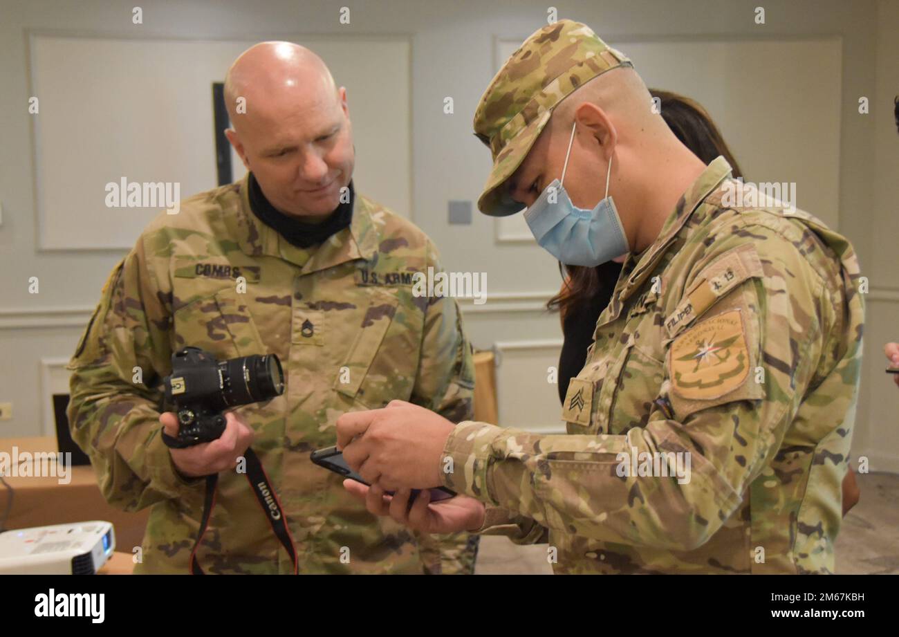 Sgt. Audino Saavedra (Servicio Nacional Aeronaval or SENAN), shows Sgt. 1st Class Joel Combs (3175th MP Co. a photo taken with his cell phone during a Macro-photography practical exercise. The exercise was a part of a National Guard Bureau State Partnership Program Subject Matter Expert Exchange on crime scene investigation in Panama City 12-14 April, 2022. Stock Photo