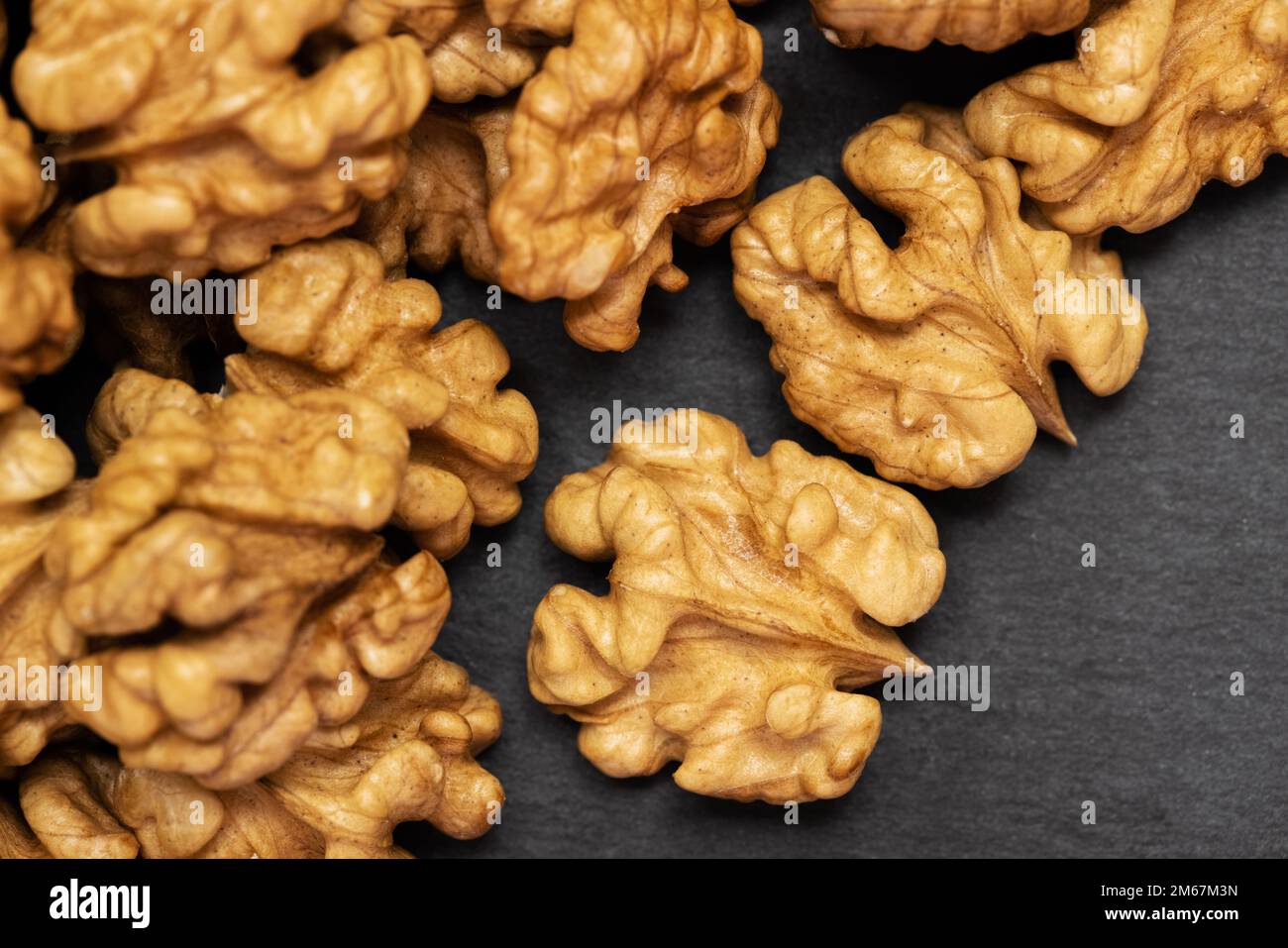 Walnuts. Walnut kernels on dark black stone background. Top view, flat lay Stock Photo