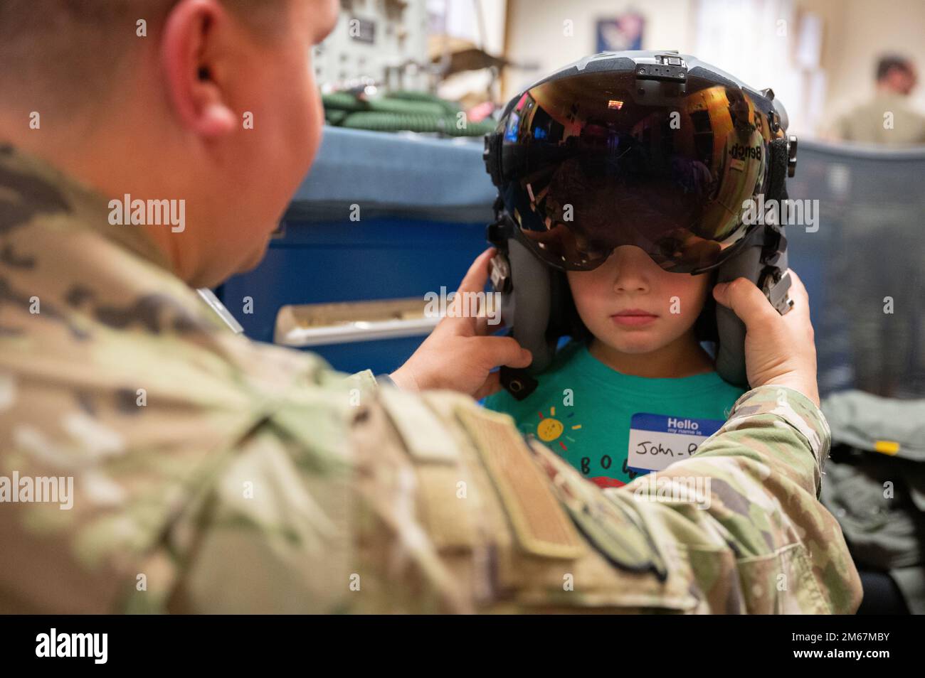 U.S. Air Force Tech Sgt. Howard King, 48th Operational Support Squadron Aircrew Flight Equipment noncommissioned officer in charge, fits a flight helmet on a child during a Bring your Child to Work Day hosted by the 492nd Fighter Squadron, at Royal Air Force Lakenheath, England, April 13, 2022. The 48th Fighter Wing recognizes the important role that military children play in the community. (U.S. Air Force by Airman First   Class Jacob Wood) Stock Photo