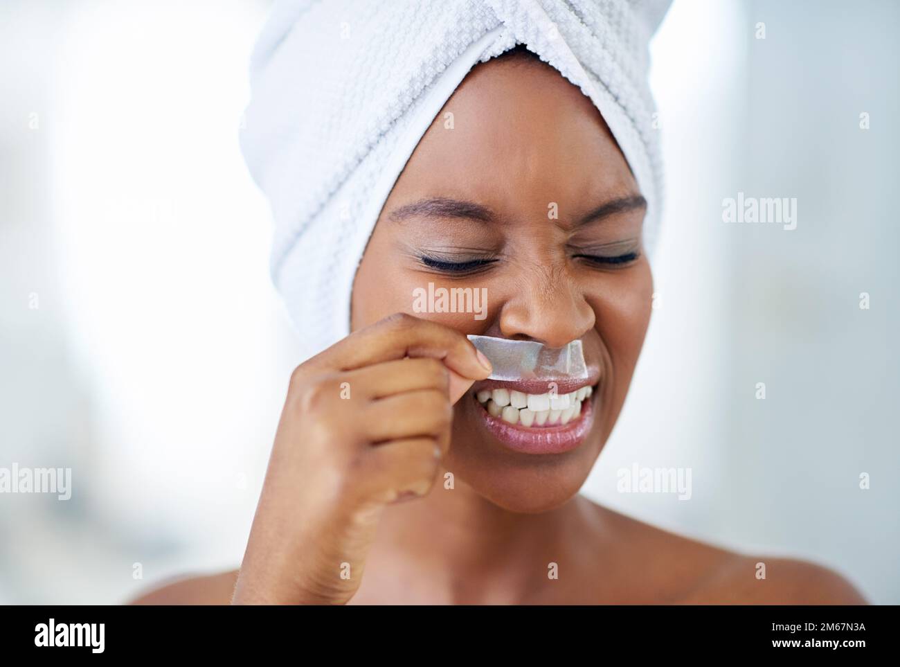 Ouch. an attractive young woman rimacing while waxing her upper lip. Stock Photo