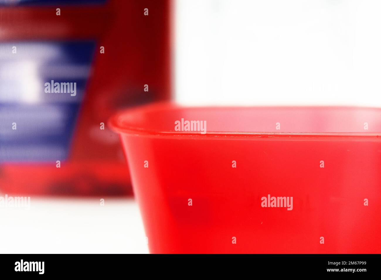 liquid medication and shot cup cold and flu season red medication Stock