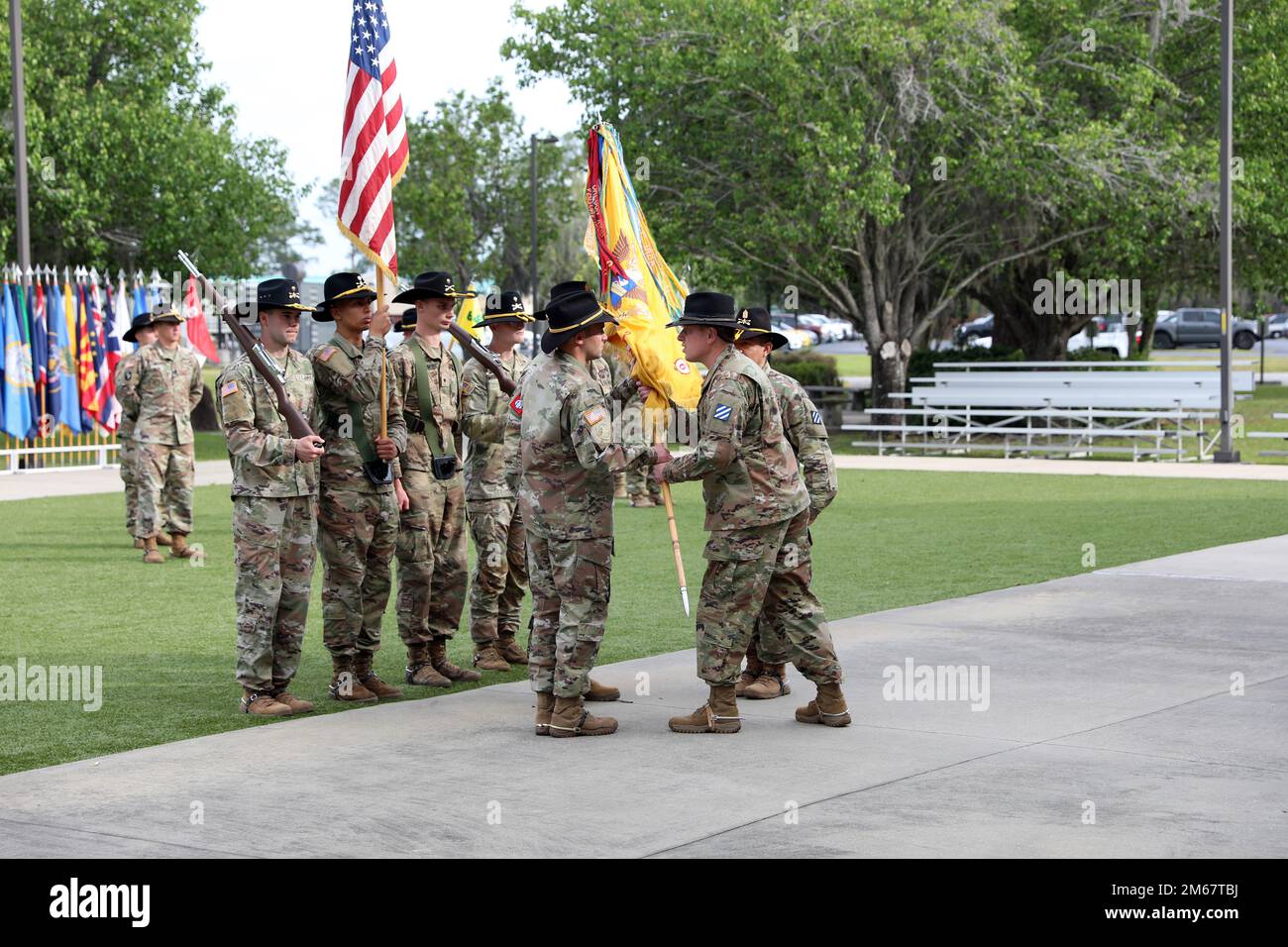 Lt. Col. Thomas Lamb, center, receives the colors from Command Sgt. Maj. Johnny Herrera-Lozano, right, and passes them to Command Sgt. Maj. Eddy Perez, left, symbolizing Perez as the new senior enlisted advisor for the 'Mustang Squadron,' 6th Squadron, 8th Cavalry Regiment, 2nd Armored Brigade Combat Team, 3rd Infantry Division, at Cashe Garden on Fort Stewart, April 14, 2022. The passing of the unit colors is a time-honored tradition that signifies the change of responsibility from one command sergeant major to the next in order to serve as the units caretaker and senior enlisted advisor to t Stock Photo