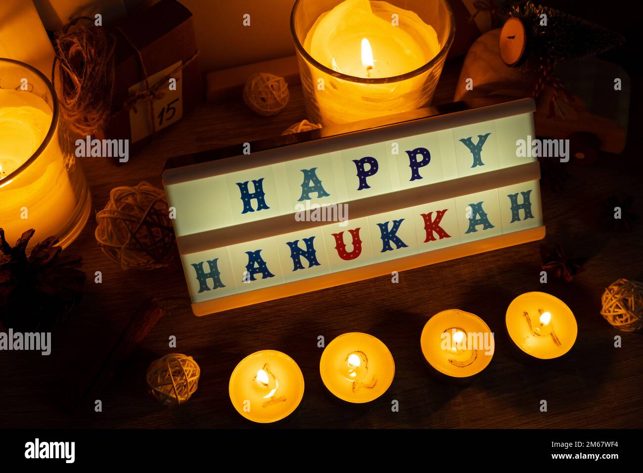Four Candles with advent calendar Lightbox with text HAPPY HANUKKAH  Traditional Burning Christmas Wax Candles with numbers counting down for  Christmas. Beautiful Advent At Home. Festive Candlelight And Dark  Background. Christmas eve Stock ...