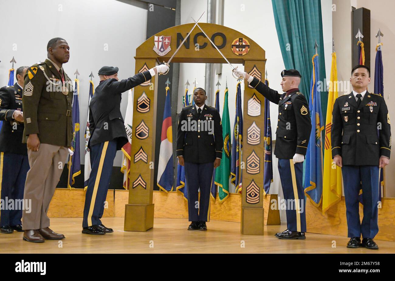 U.S. Army Sgt. Joshua Bell, Headquarters and Headquarters Company, 30th Medical Brigade crosses the archway during a Noncommissioned Officer Induction Ceremony, April 14, 2022 at Sembach, Germany. Twenty-five newly promoted Soldiers were inducted as members of the NCO corps. Stock Photo