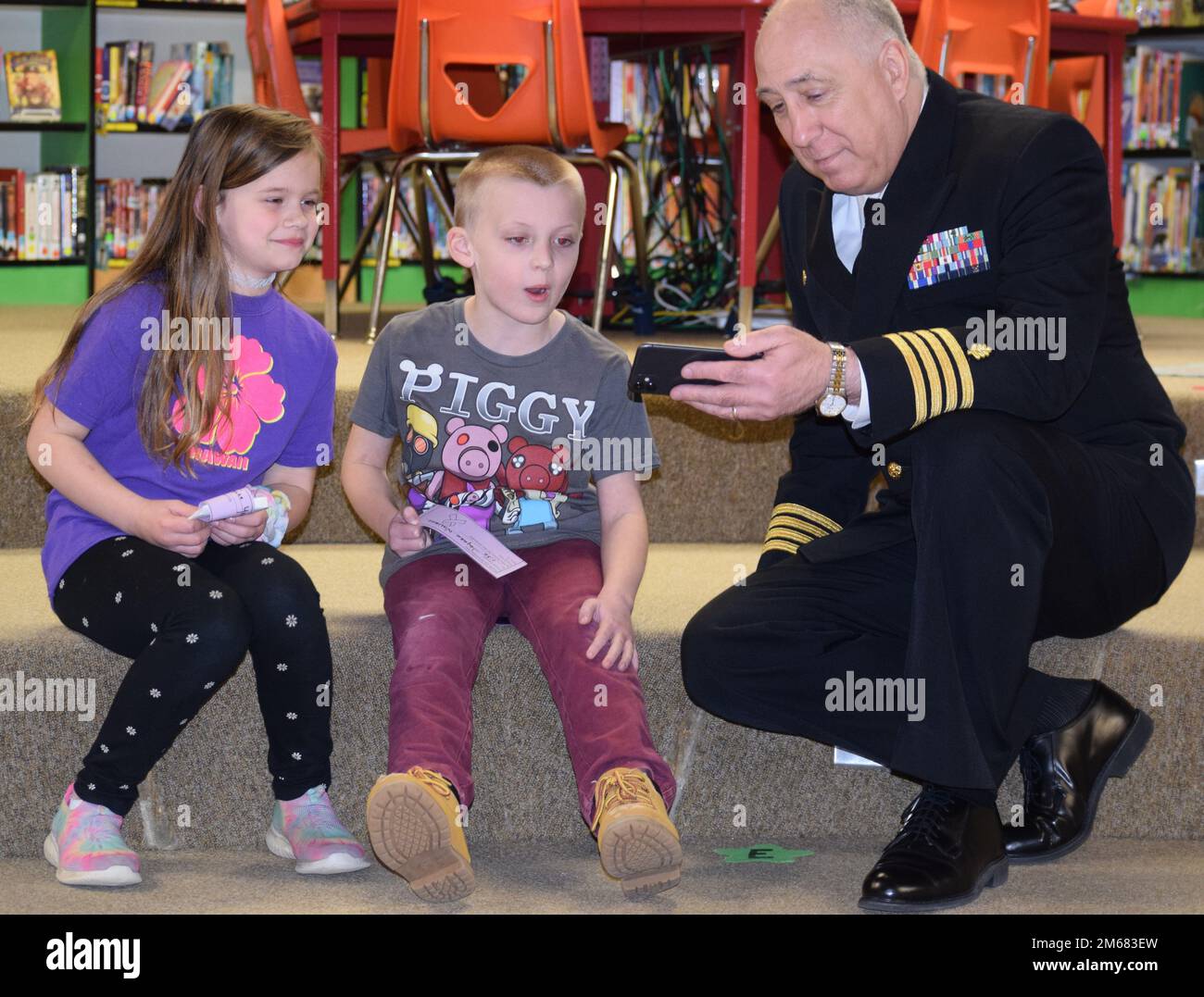 From one military kid to another… Capt. Patrick Fitzpatrick, Naval Hospital Bremerton director and Navy Medicine Readiness Training Command Bremerton commanding officer and military kid, take a moment to share his military kids with two other military kids at Burley Glenwood Elementary, Port Orchard, Washington. Fitzpatrick spoke to the all the military kids at the school in conjunction with April being Month of the Military Child (official Navy photo by Douglas H Stutz, NHB/NMRTC Bremerton public affairs officer). Stock Photo
