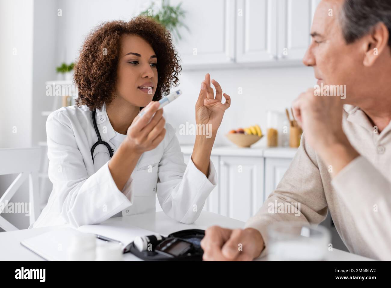 curly african american doctor explaining how to use lancet pen to
