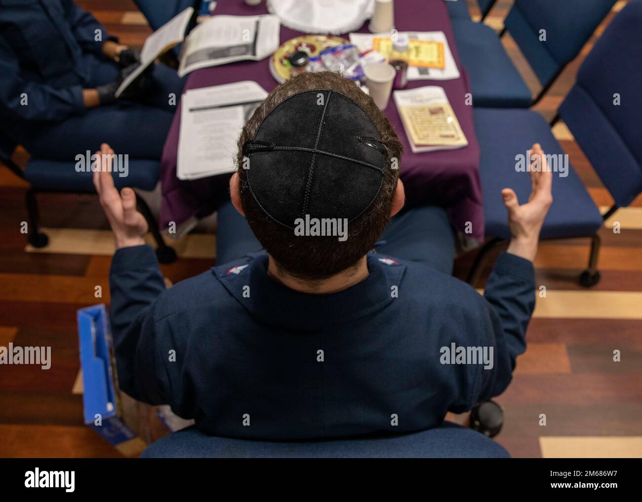 220416-N-IV962-1031    PACIFIC OCEAN (April 16, 2022) – Interior Communications Electrician 3rd Class Ohr Klein celebrates Passover with a seder in the chapel of amphibious assault ship USS Makin Island (LHD 8), April 16. Seder is a ritual feast that marks the beginning of the Jewish holiday Passover and is traditionally celebrated on the first and second nights of the eight day celebration, which commemorates the exodus of Jews in slavery from Egypt. Makin Island is underway conducting routine operations in U.S. 3rd Fleet. Stock Photo