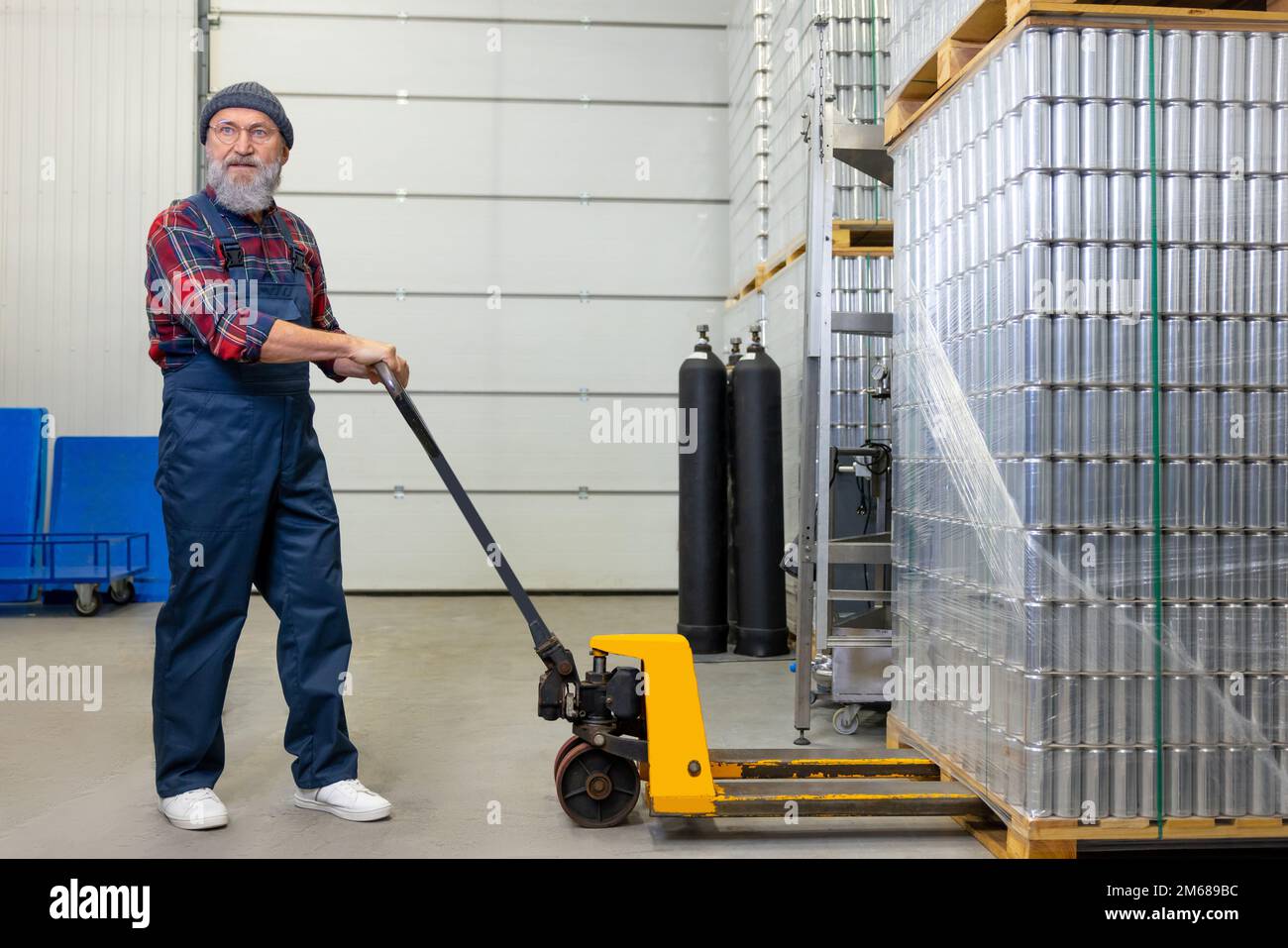 Worker unloading cargo in a factory warehouse Stock Photo - Alamy