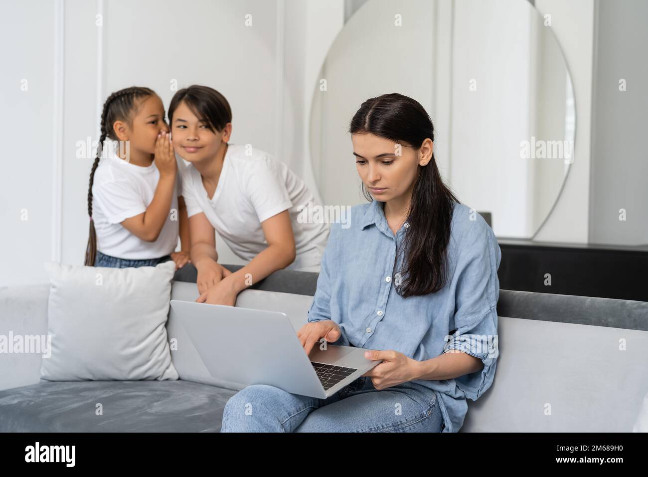 mother using laptop near asian kids talking at home,stock image Stock Photo