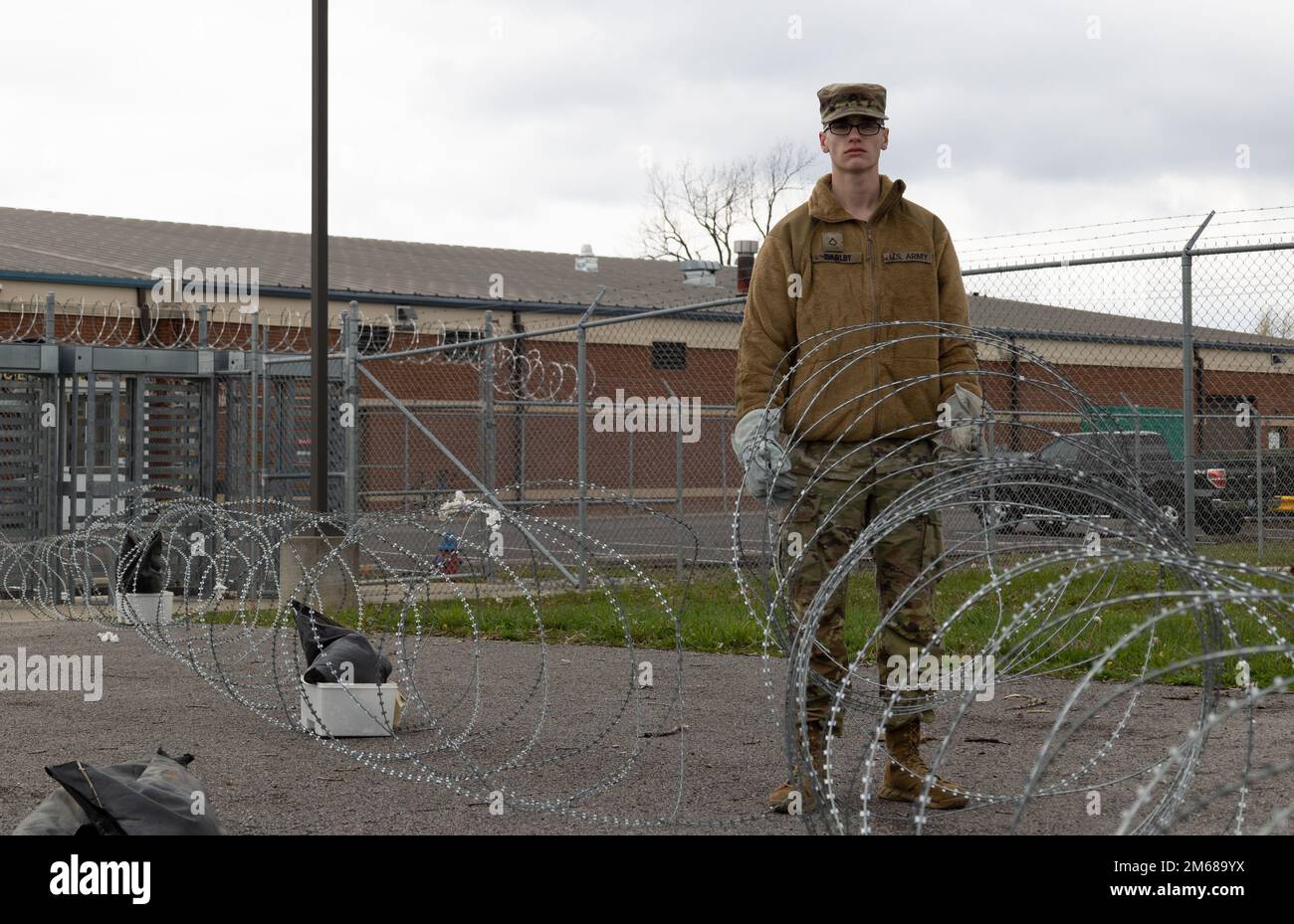 Pfc. Trevor Thurlby, help desk technician, 1st Theater Sustainment Command, lays concertina wire during a command post exercise at Fort Knox, Kentucky, April 18, 2022. Command post exercises are conducted to increase readiness of Soldiers. Stock Photo