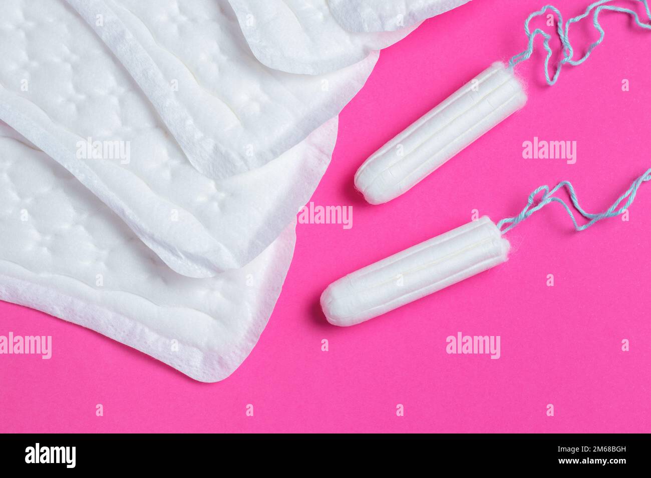 Menstrual tampons and pads on a pink background. Menstruation cycle