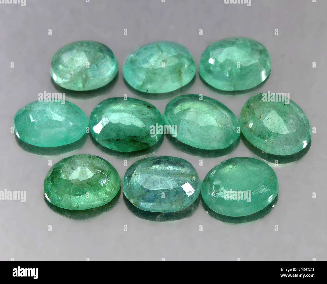 Natural stone green emerald on a gray background Stock Photo Alamy