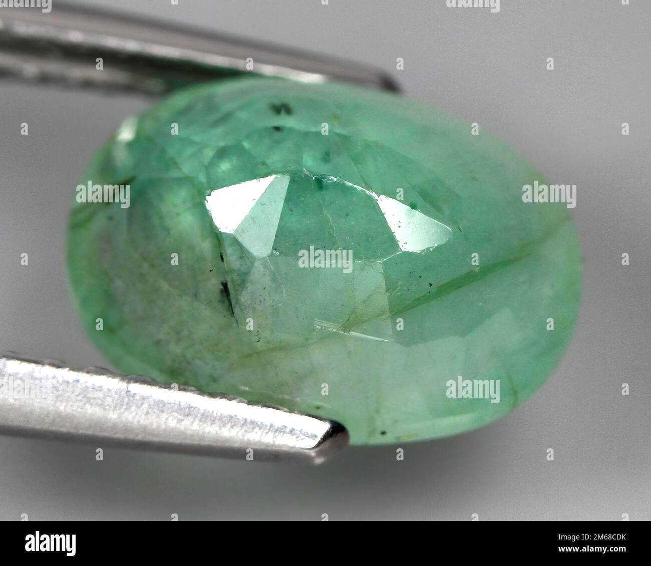Natural stone green emerald on a gray background Stock Photo