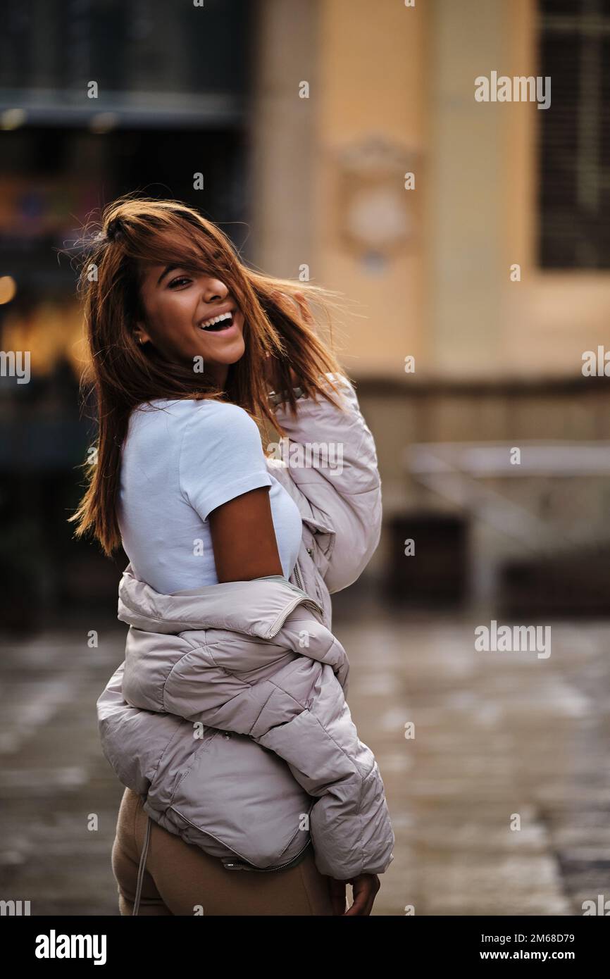 Young Moroccan woman looking at camera and laughing while posing on the street. Stock Photo