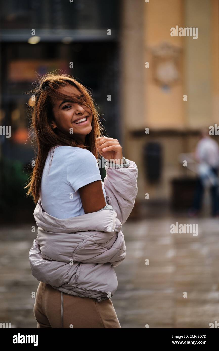 Young Moroccan woman looking at camera and smiling while posing on the street. Stock Photo