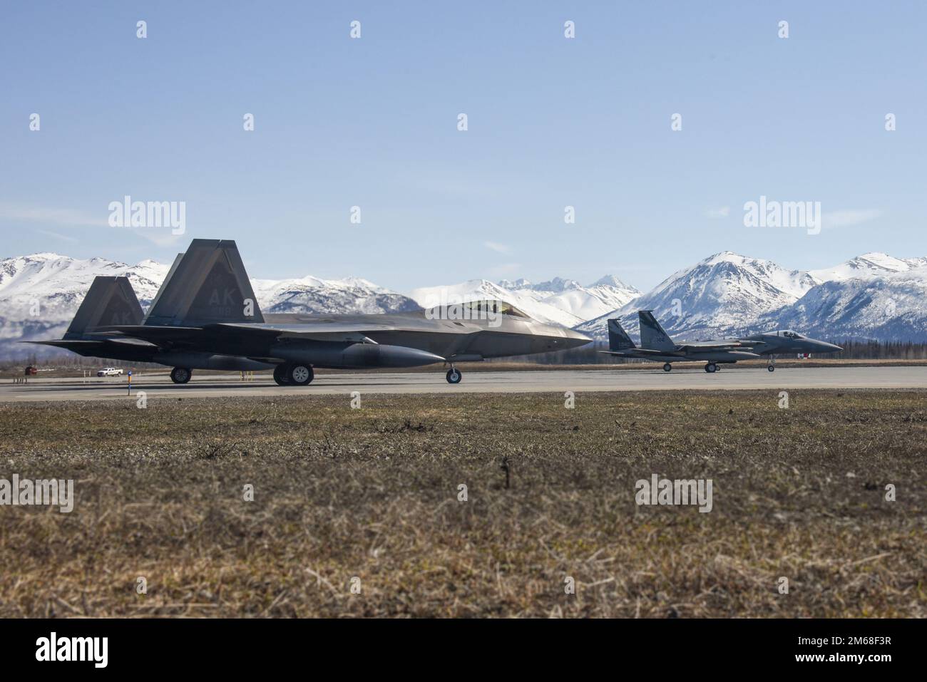 Two F-15C Eagles from the 144th Fighter Wing and two F-22 Raptors from the 3rd Fighter Wing prepare to take off from Joint Base Elmendorf-Richardson, Alaska, April 18, 2022, during an Aerospae Control Alert training scramble. It has been almost a decade since F-15 Eagles have sat alert in the region, protecting the airspace of the United States and Canada. The overall alert mission and corresponding training missions at JBER focused on fighter integration between fourth-generation F-15 Eagles and fifth-generation F-22 Raptors and their ability to interoperate seamlessly. Stock Photo