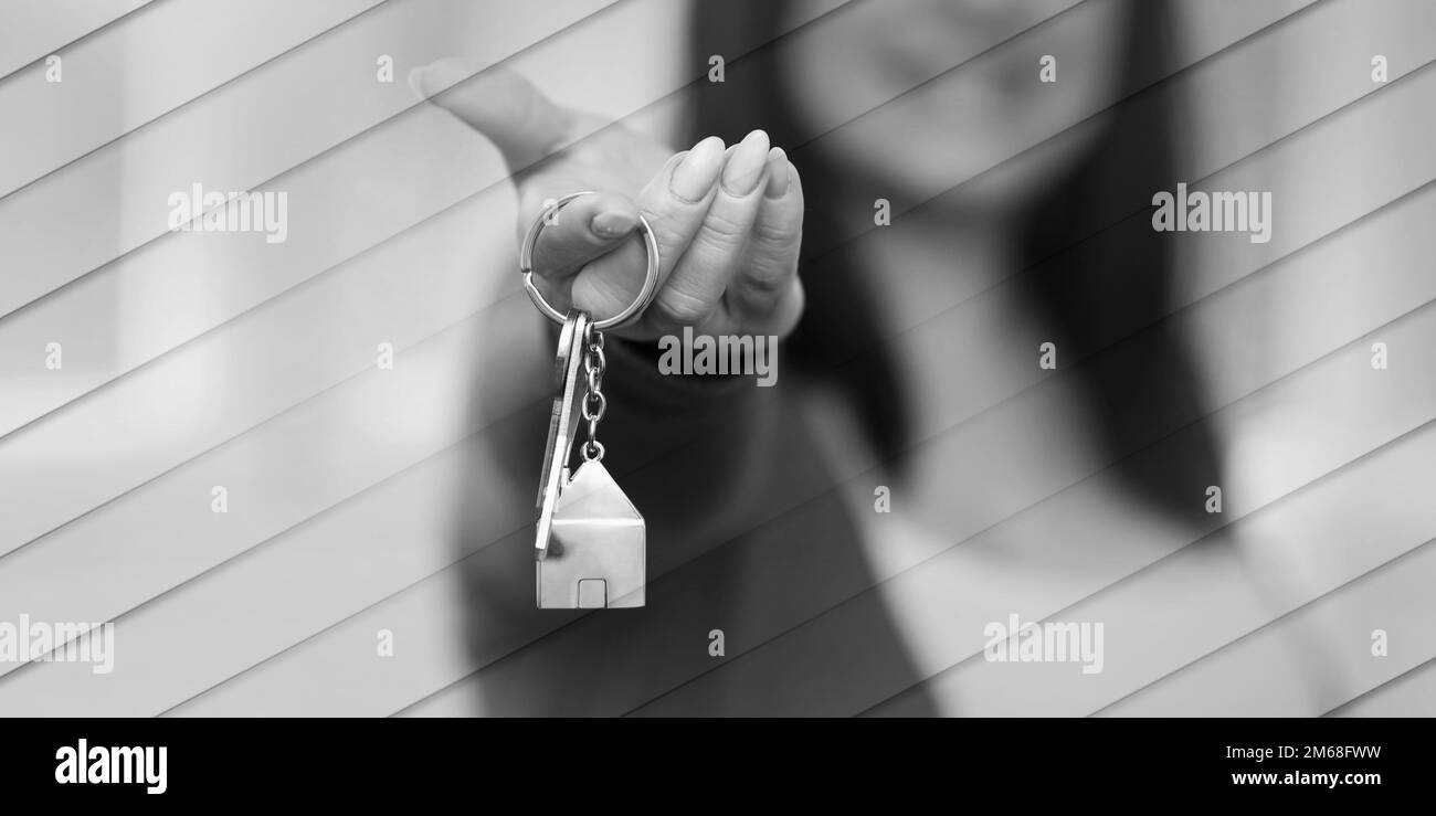 Young woman holding out house keys, light effect, geometric pattern