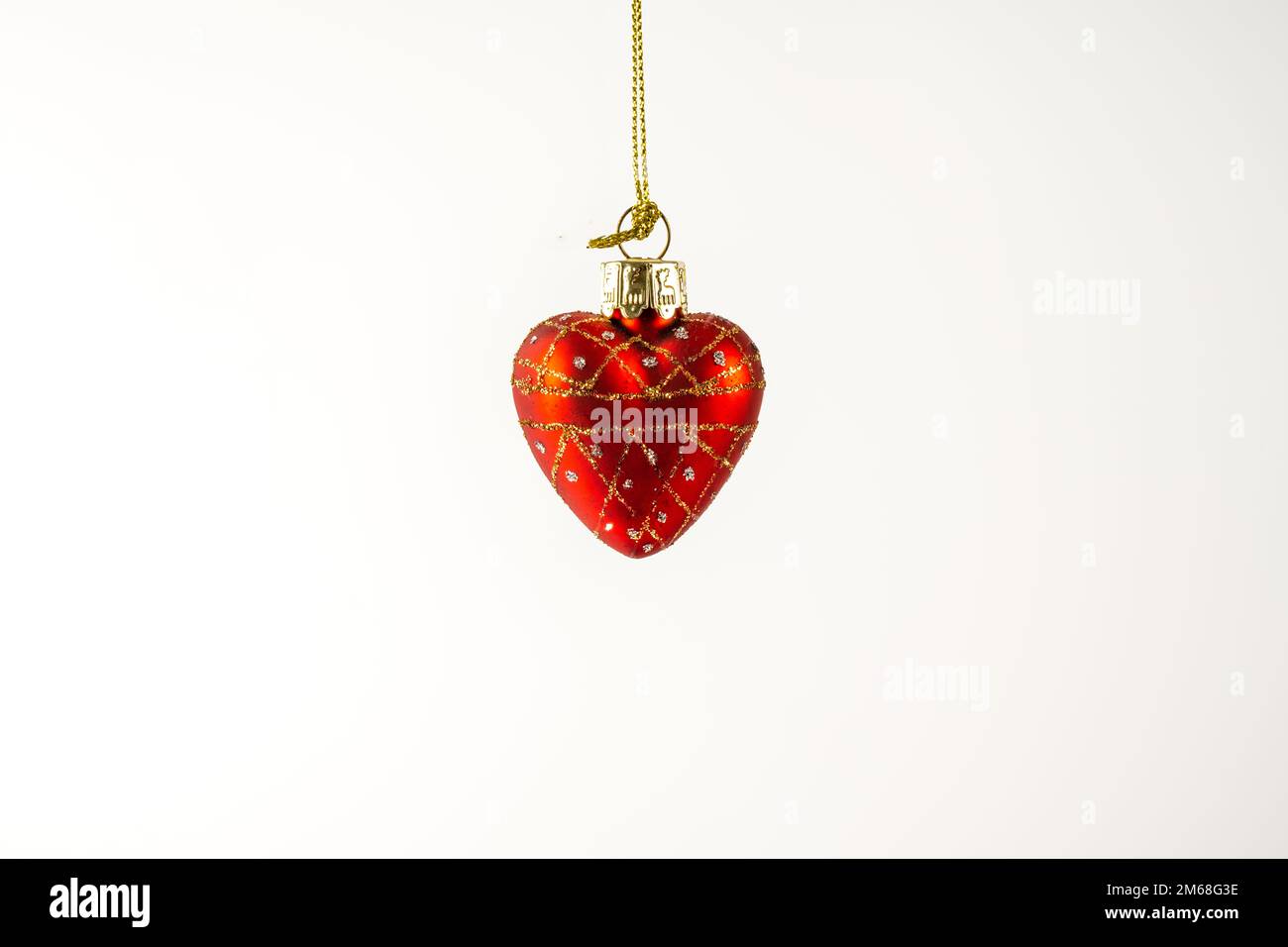 Red  love heart Valentine pendant suspended and isolated over a white background Stock Photo