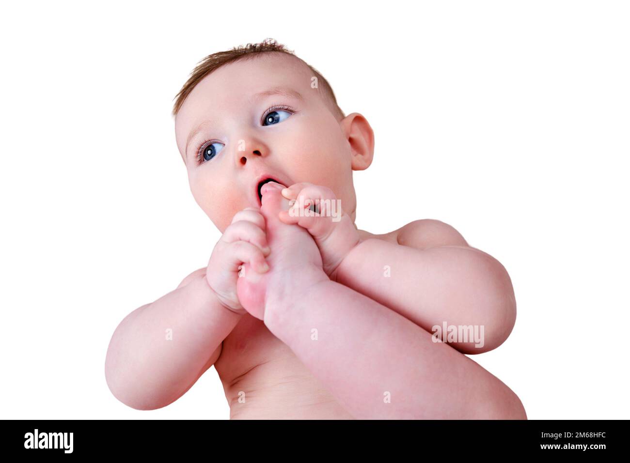 Portrait of a happy infant baby pulling his leg into his mouth, six to