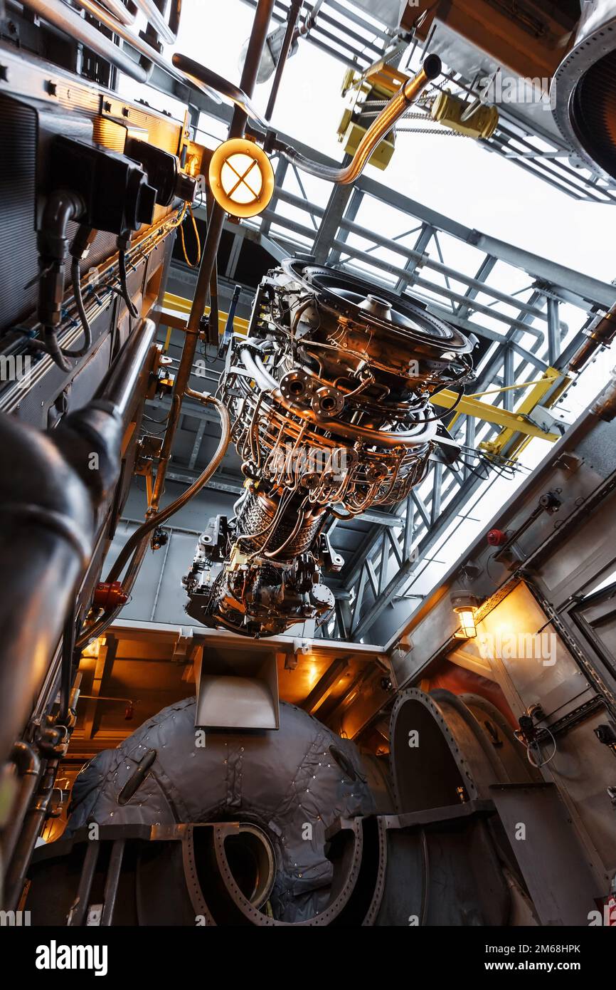 The engine of a gas turbine compressor hangs on a crane during installation in a module for generating electricity Stock Photo