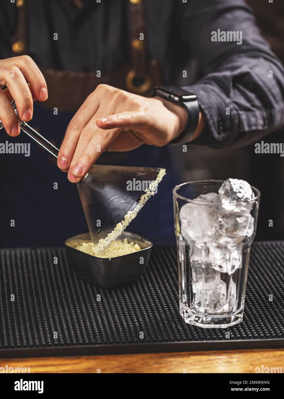 Barman roll the margarita glass rim in sugar Stock Photo