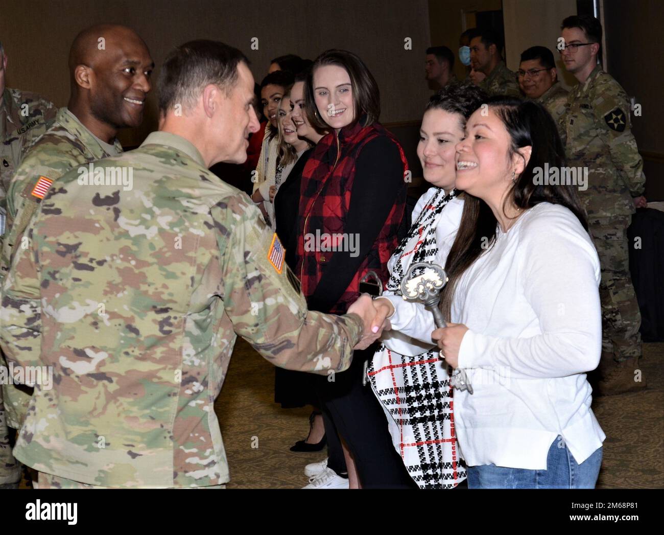 Mayor Vanessa Raster, right, is presented with the key to The Bricks housing community by Col
