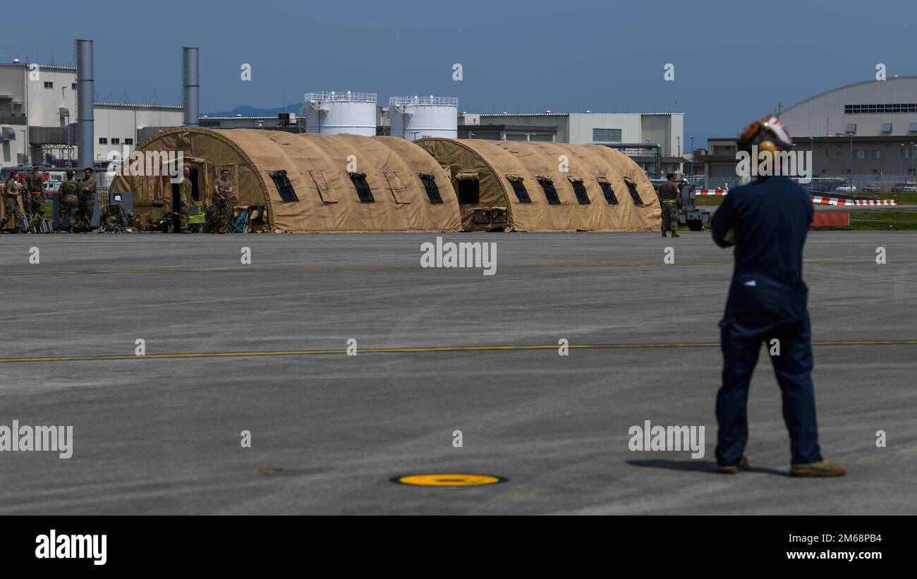Airmen assigned to yokota air base stand next to two forward operating