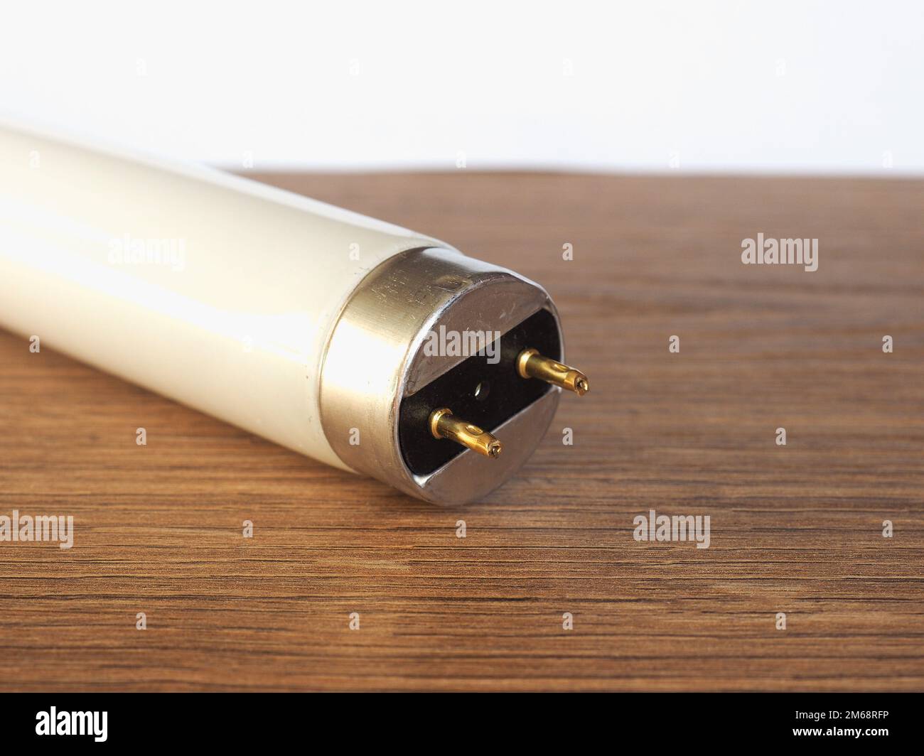fluorescent tube light bulb over wooden desktop Stock Photo Alamy