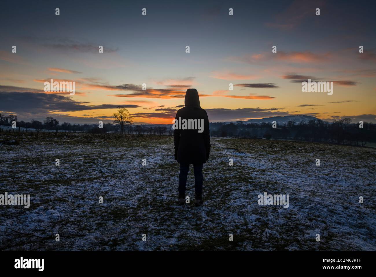 Female on a winter walk in the Ribble Valley at sunset. Stock Photo