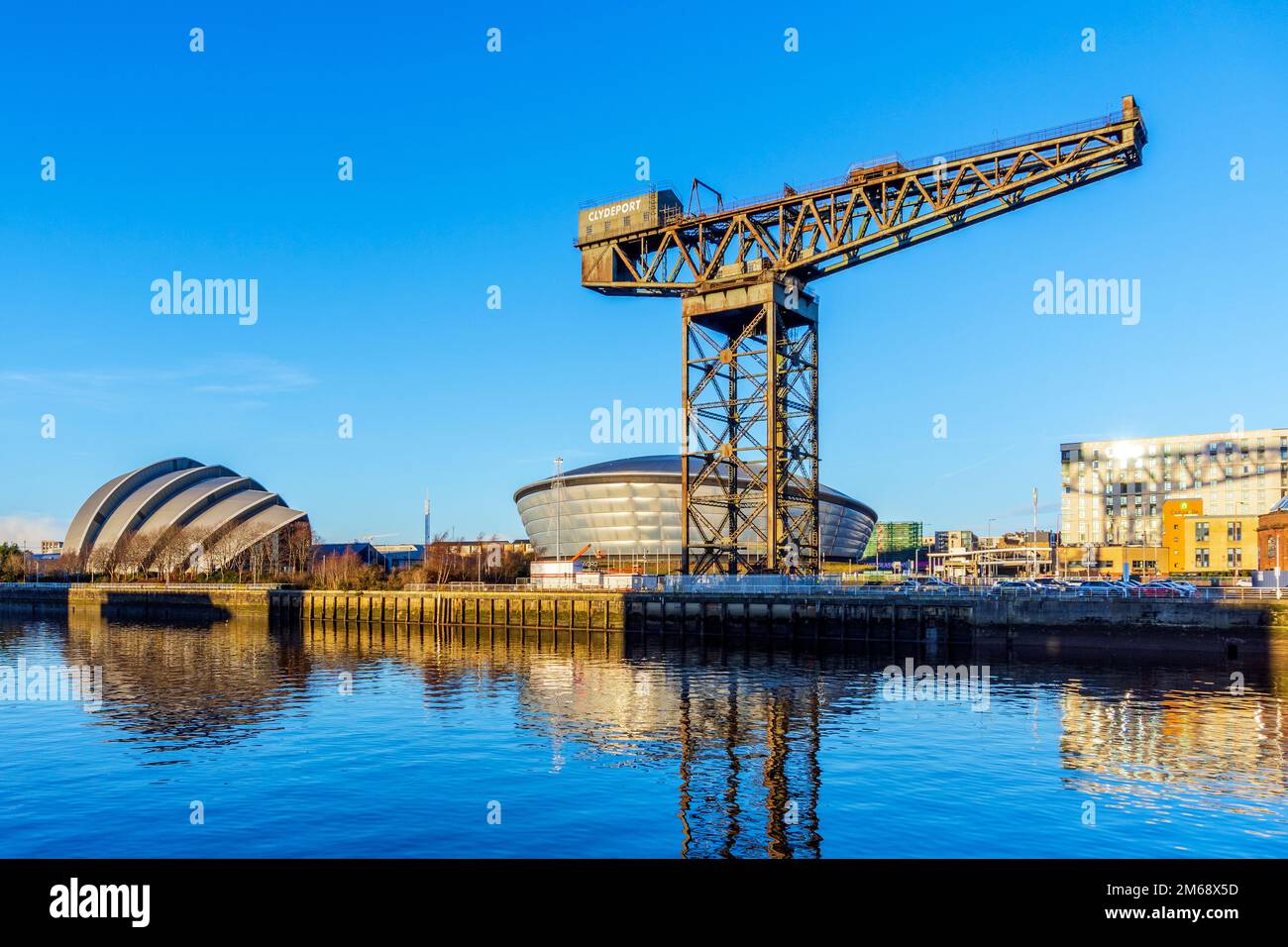 The Anderston Crane standing at the edge of the River Clyde with the Armadillo and SECC entertainment venues in the background, Glasgow, Scotland, UK Stock Photo