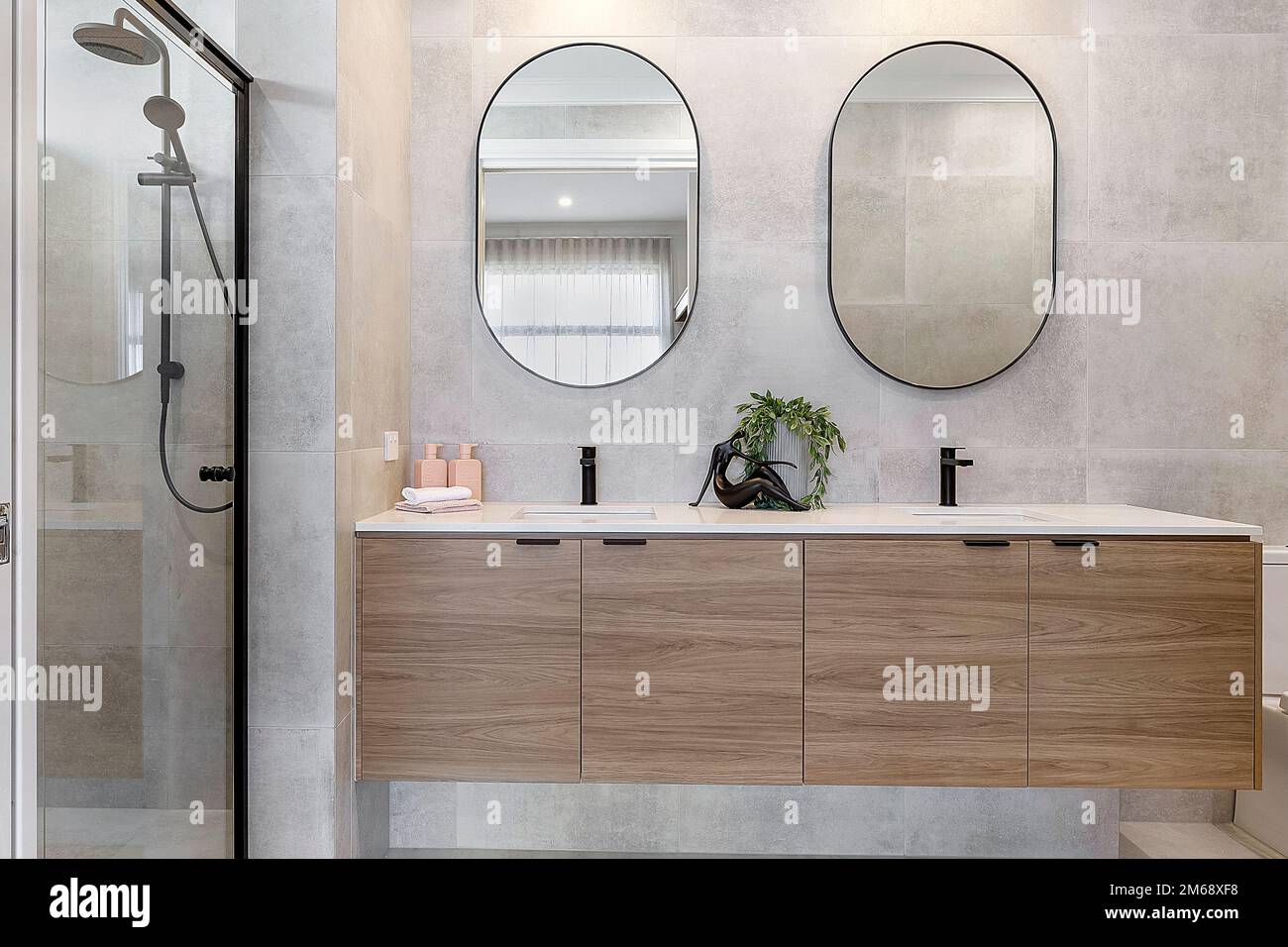 modern bathroom with shower, wooden vanity, duo sink and double mirrors ...