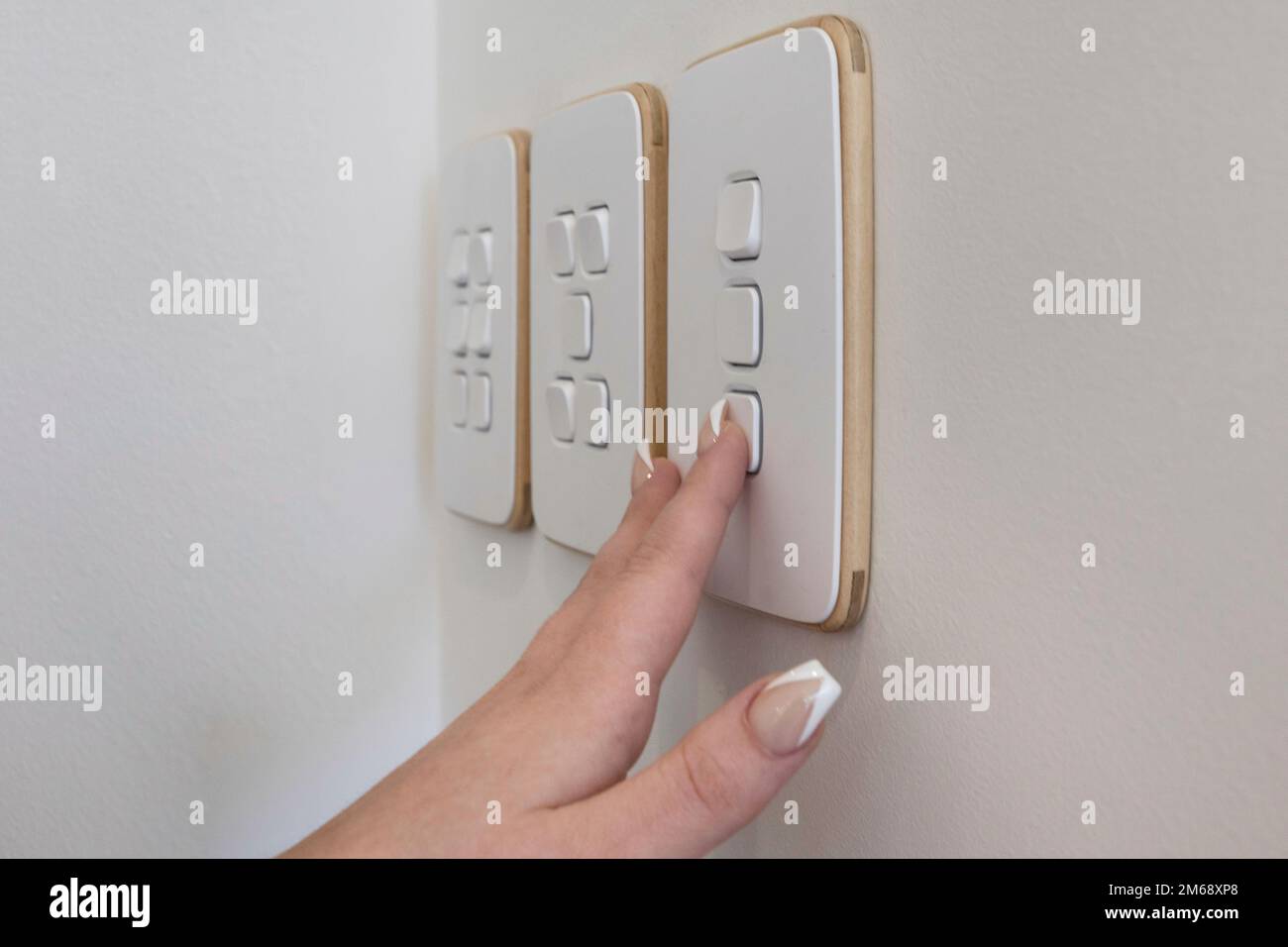 Manicured hand turning light switch on or off Stock Photo Alamy