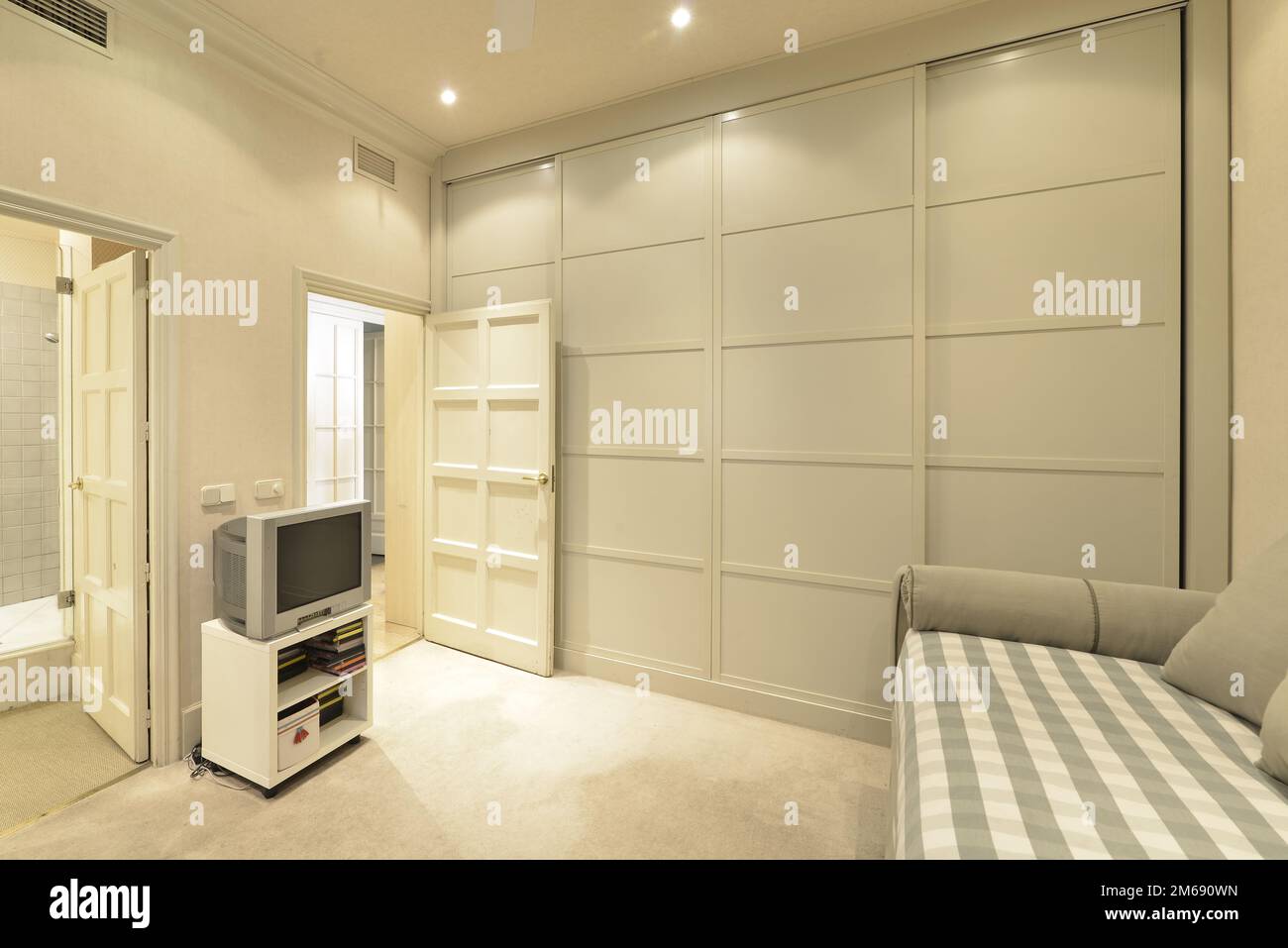 Bedroom with builtin wardrobe with gray wooden sliding doors and