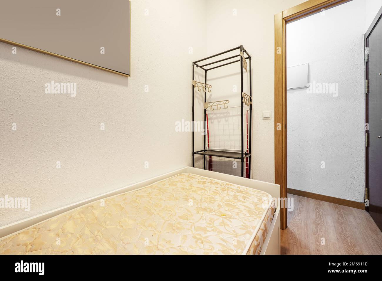 Bedroom with a youth bed with a mattress without clothes and an open