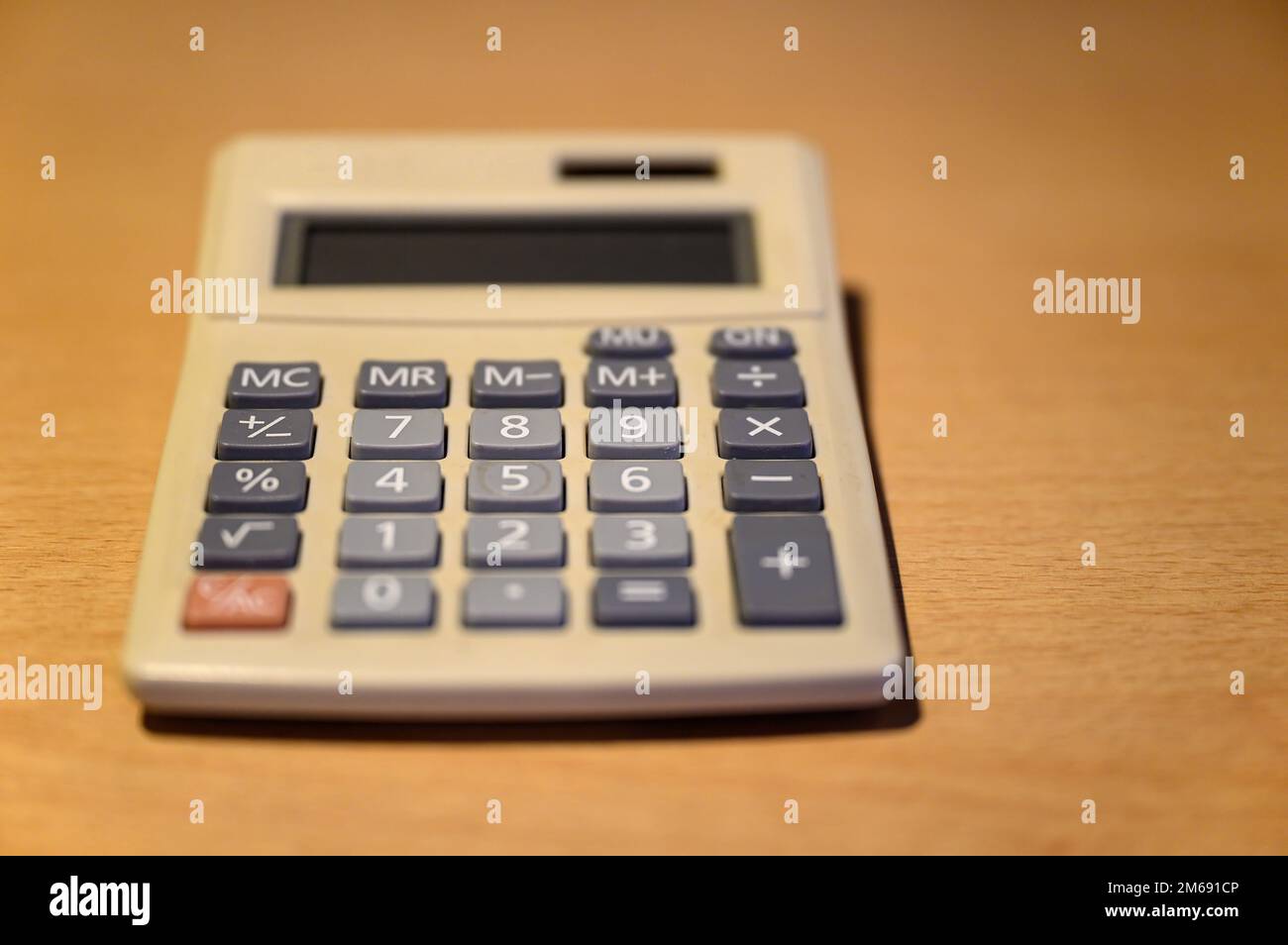 Electronic calculator on a desk. Basic solar desk calculator representing old technology. Focus on number 8 with shallow depth of field. No branding. Stock Photo