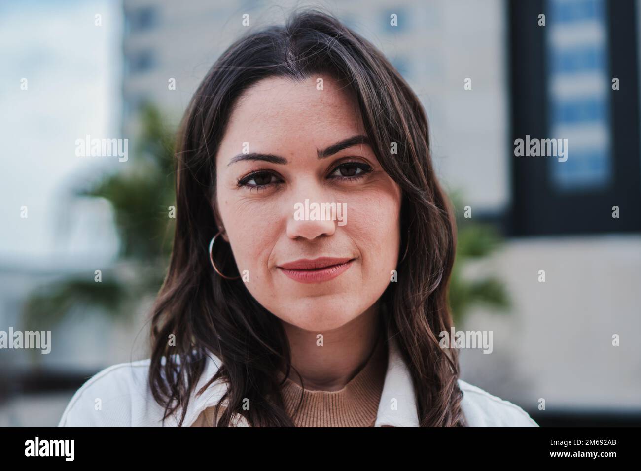 Close up portrait of a woman face. Front view of a girl head. One teenage isolated female smiling looking at camera. Caucasican girl standing outdoors. High quality photo Stock Photo