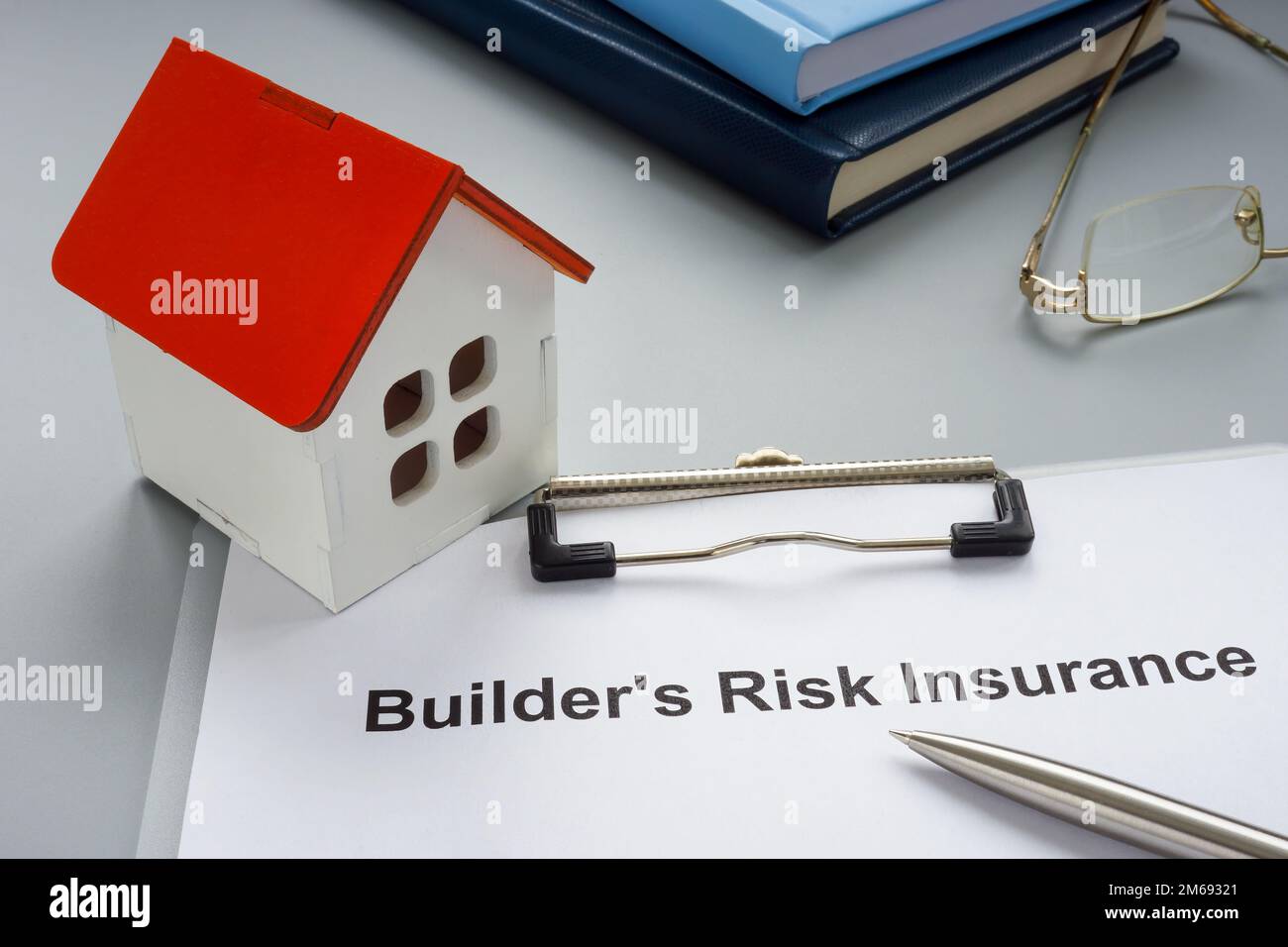 Model of house and builders risk insurance policy. Stock Photo