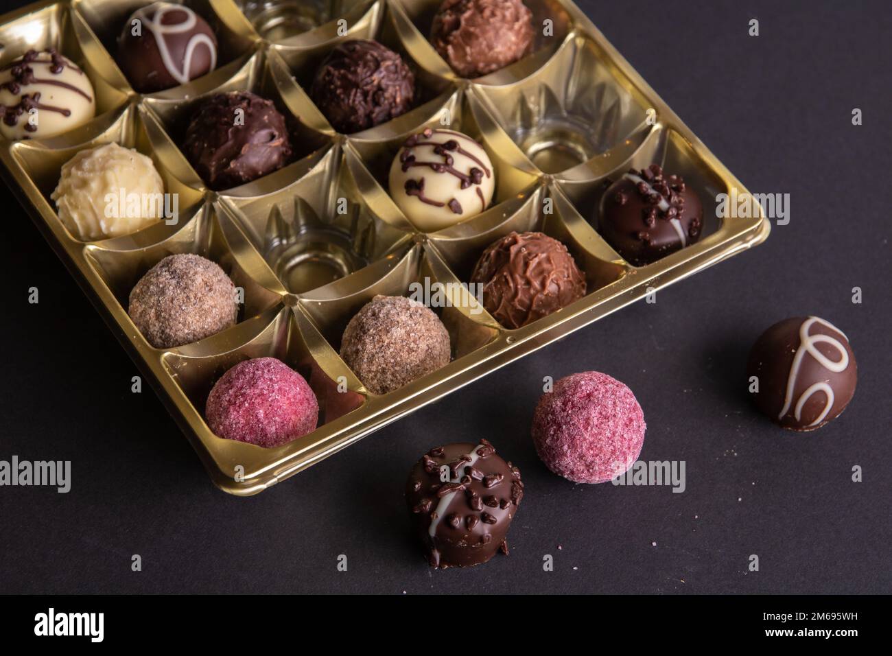 photo of different chocolates in a box next to the box there are