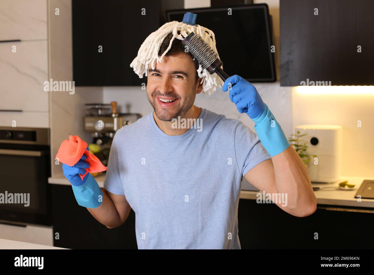 Funny man combing his mop hair Stock Photo