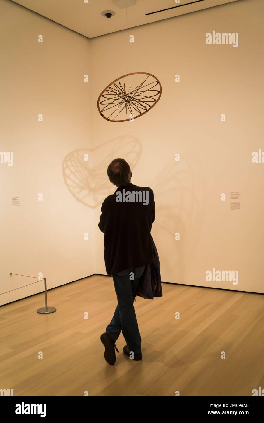 Man looking at Aleksandr Rodchenko sculpture Spatial Construction no. 12 c. 1920, MOMA, The Museum of Modern Art, New York City, USA Stock Photo