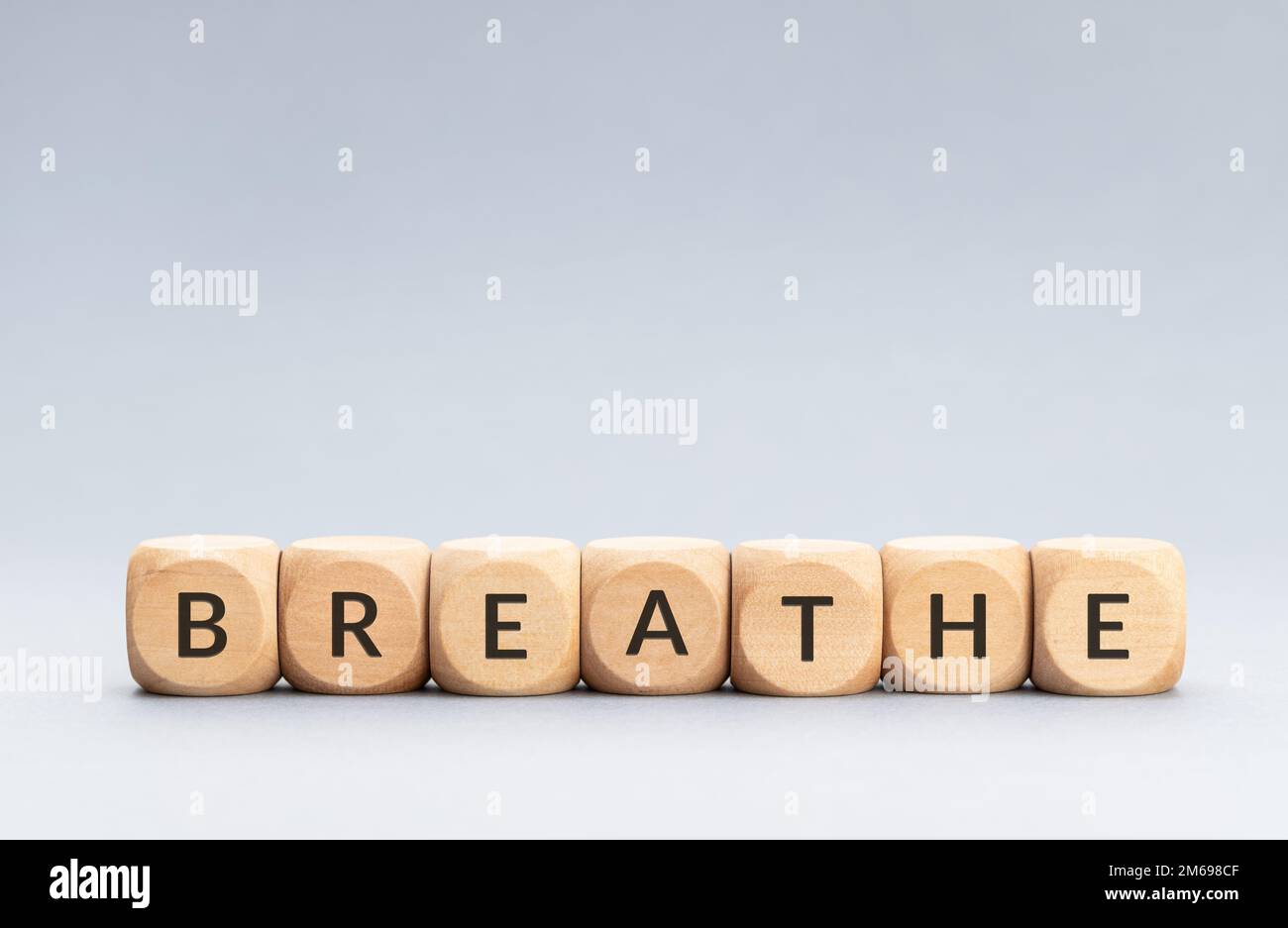 Breathe word on wooden blocks on gray background. Copy space Stock Photo
